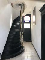 a hallway with a black staircase and a black door at La clef Sithieu in Saint-Omer