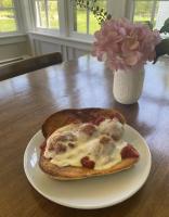 a slice of pizza on a plate on a table at Stone Hearth Inn and Eatery in Chester