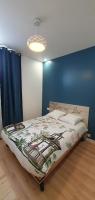 a bed in a room with a blue wall at El Dar in Cholet