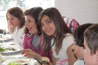 Un grupo de chicas sentadas en una mesa comiendo comida en Hôtel Valentin pied des pistes, en Les Deux Alpes
