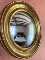 a gold mirror reflecting a room with a table at La maison du pech in Monteils