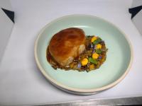 Un plato de comida con carne y verduras en una mesa. en Belcruz family lodge, en Monteverde