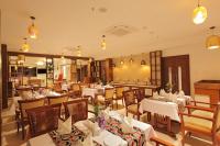 a restaurant with white tables and chairs and lights at HOTEL MARIA PARK in Mūvattupula