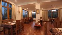 ein Restaurant mit Holztischen und -stühlen und Fenstern in der Unterkunft Hotel Youthok Heritage in Leh