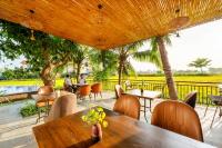 Un restaurante con mesas y sillas y una piscina. en Sunkised Paddy Hoi An Villa, en Hoi An