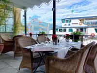 Una mesa con sillas y un barco al fondo. en Hotel Cannero, en Cannero Riviera