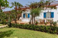 a garden with a house with blue shutters at Villa in the Garden in Kokkini Khanion