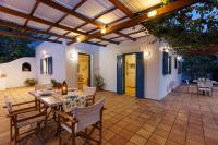 a patio with a table and chairs and a wooden ceiling at Villa in the Garden in Kokkini Khanion