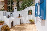 a white wall with blue doors and flowers in a courtyard at Villa in the Garden in Kokkini Khanion