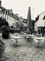 a group of tables and chairs with an umbrella at Ty Kaz Old Kemper in Quimper