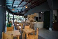 um restaurante com mesas e cadeiras de madeira e um bar em Hidden Lagoon Resort em Panglao City