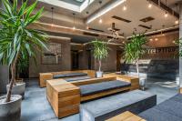 a lobby with wooden tables and potted plants at IOTA Hotel Tbilisi in Tbilisi City