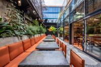 a row of benches in a restaurant with plants at IOTA Hotel Tbilisi in Tbilisi City