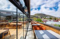 a balcony of a restaurant with tables and chairs at IOTA Hotel Tbilisi in Tbilisi City