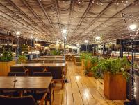 a restaurant with tables and potted plants and lights at IOTA Hotel Tbilisi in Tbilisi City