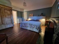 a bedroom with a bed and a wooden floor at Bon Chez Nous in Saint-Amand-Jartoudeix