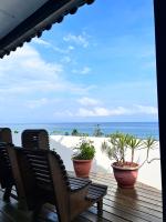 a deck with chairs and plants on the beach at Bridge12th B&amp;B in Yanliau