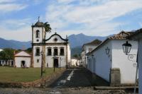 an old church with a clock tower in a town at Pousada Arte Urquijo in Paraty