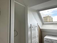 a bathroom with a skylight and a window at Charmant appartement chez Pat in Caen