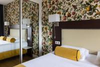 a hotel room with two beds and floral wallpaper at Brit Hotel Europ Bergerac in Bergerac