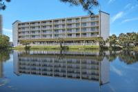 an office building with its reflection in the water at Baymont by Wyndham Panama City Beach in Panama City Beach