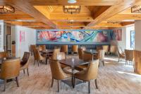 uma sala de jantar com tetos de madeira, mesas e cadeiras em The Karol Hotel, St. Petersburg Clearwater, a Tribute Portfolio Hotel em Clearwater