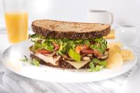 The Cromwell, A Caesars Destination في لاس فيغاس: شطيرة على طبق مع رقائق البطاطس وكوب من عصير البرتقال