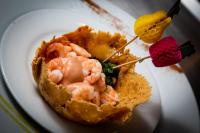 Un plato blanco con un trozo de comida con camarones. en Hotel Manantial Valencia, en Valencia