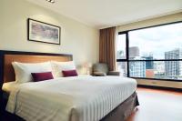 a hotel room with a large bed and a large window at Bandara Suites Silom, Bangkok in Bangkok