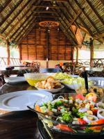 亭可马里The Tottam Beach Hotel - Trincomalee的桌子上摆着许多盘子食物