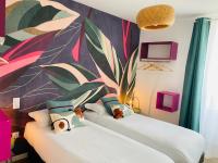 two beds in a room with a mural on the wall at L’escale 175 in Divatte sur Loire