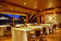 a dining room with tables and chairs with white table cloth at Dos Bahias Lake Resort in Villa La Angostura