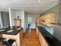 a kitchen with a black counter top and wooden cabinets at Le logis des Halles in Cerizay