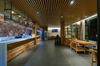 Un restaurante con un mostrador, mesas y sillas. en XMAN Sunrise Peaks Resort, en Zhangjiajie