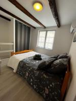 a bedroom with a bed in a room with a window at #Le Rue des 2 Porches #F2 avec Cours #HyperCentre in Brive-la-Gaillarde