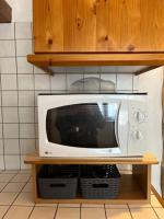 a microwave sitting on a shelf in a kitchen at #Le Rue des 2 Porches #F2 avec Cours #HyperCentre in Brive-la-Gaillarde