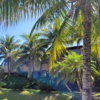a resort with palm trees and a swimming pool at Pousada Casa do Catavento in Búzios