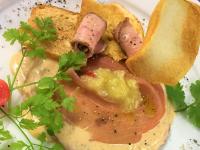 ein Teller mit Essen, darunter ein Sandwich mit Schinken und Tomaten. in der Unterkunft Parkhotel Krone in Emmendingen