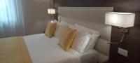 Un dormitorio con una cama con sábanas y almohadas blancas. en Orchid Luxury Suite, en Pescara