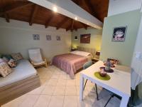 a bedroom with a bed and a couch and a table at Semelia&#39;s Guest house in Spáta