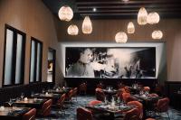 a dining room with tables and a large screen at Harrah's Kansas City, A Caesars Destination in Kansas City