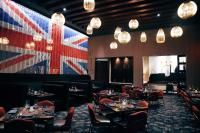 a restaurant with tables and chairs and a large flag on the wall at Harrah's Kansas City, A Caesars Destination in Kansas City