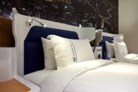 a bedroom with a white bed with a blue headboard at Airline Inn Green Park Way in Taichung