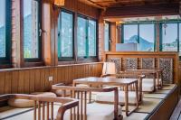 a row of tables and chairs in a room with windows at H&amp; Jiufen The Dragon Inn in Jiufen