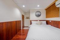 a bedroom with a bed with white sheets and wood paneling at H&amp; Jiufen The Dragon Inn in Jiufen