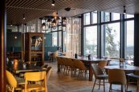 un ristorante con tavoli e sedie e grandi finestre di Ski-Inn Kultakero a Pyhätunturi