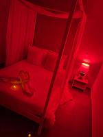 a bedroom with a bed with a red light at Nid’Ange in Piolenc