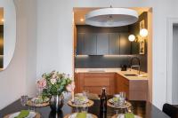 a kitchen with a table with flowers and wine bottles at Le Goya - Appartement 4 chambres centre ville de Rennes in Rennes