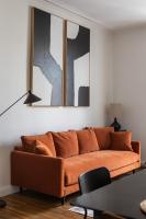 an orange couch in a living room with two mirrors at Le Goya - Appartement 4 chambres centre ville de Rennes in Rennes