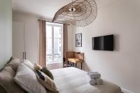a bedroom with a bed and a couch and a television at Le Goya - Appartement 4 chambres centre ville de Rennes in Rennes